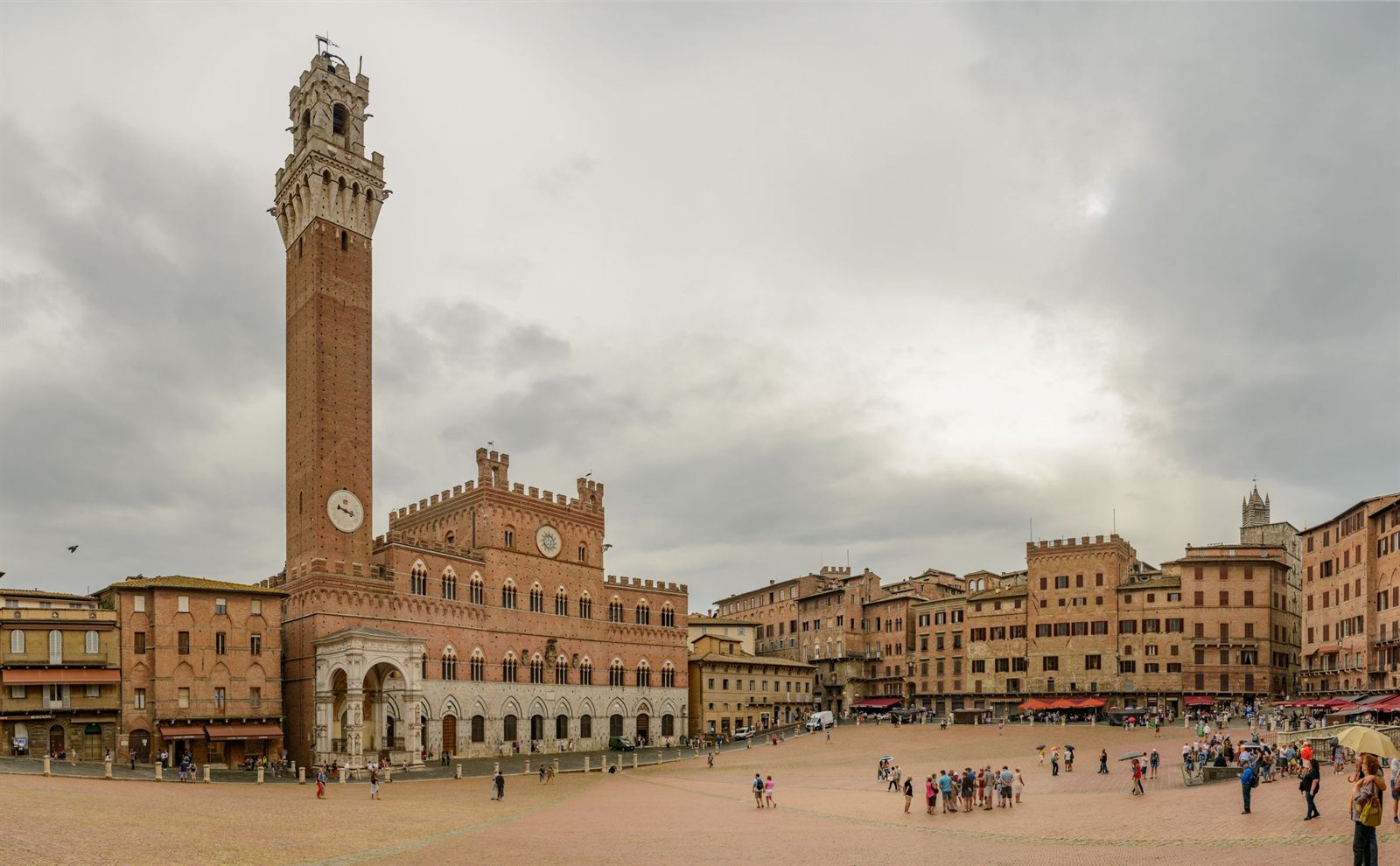 Piazza del Campo in Siena with the tall Torre del Mangia and strolling visitors